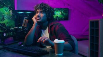 Bored Indian Arabian Latino man tired guy monitor computer networking cyberspace programmer gamer streamer play drink coffe male pc workplace late technology internet cellular online insomnia networks video