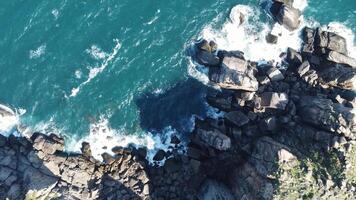 Aerial view Top down seashore. Waves crashing on rock cliff. video