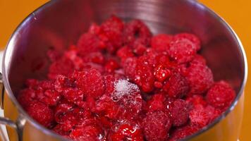 Transparent cream is put on top of raspberries in a pan video