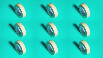 Rolls of scotch tape rotate on green surface video