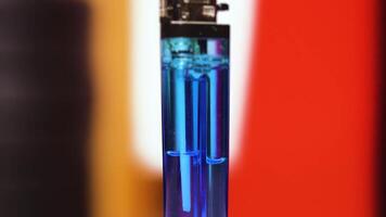 Lighter with liquid inside on moving background video