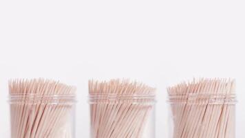 Three toothpick containers rotate on a white background video