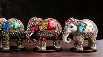 Three beautifully crafted decorative elephants stand in a row on a wooden surface, each featuring vibrant colors and stunning embellishments that capture attention and artistry. video