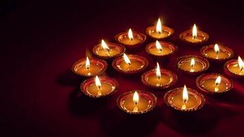 A cluster of illuminated diyas casts a warm glow in a dark setting, symbolizing hope and joy during the Diwali festival. video