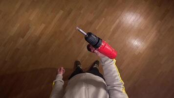 Pov first person view Confident handyman with cordless drill on parquet floor in cozy house, showcasing expertise in construction and renovation tasks video