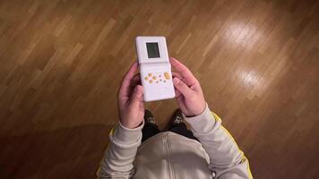 pov First person view Immerse in nostalgia with a man playing a retro handheld game console, evoking 80s and 90s memories with pixelated graphics. Enjoy the old-school fun on the go video