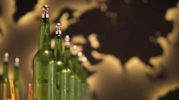Green bottles with silver caps and numbered wooden sticks are standing in a row in front of a blurred world map, possibly representing global beer or beverage industry video