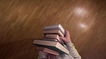 pov First person view Determined student carefully balances a stack of books on a creaky wooden floor, symbolizing the challenges and triumphs of education video