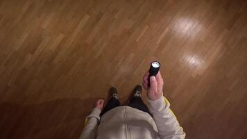 pov First person view Man explores a dark room with a flashlight, revealing a stunning parquet floor, casting shadows and creating suspense. Man turns on flashlight in room video