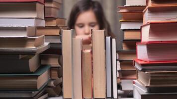 little girl in the library reading a book. education school kid science concept. a child stacks of books flips through the pages reads studies. daughter reading a book lifestyle. video