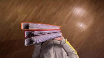 pov First person view Student carrying heavy, colorful binders symbolizes the challenges of education and time management. Man busy with office paperwork. Hard office work concept. Overwhelmed video