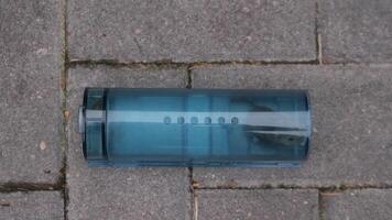 Small rodent captured alive inside a plastic, reusable trap placed on a gray stone floor, providing a humane pest control solution video