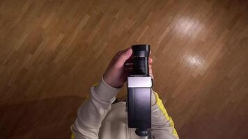 pov First person view Videographer adjusting zoom on a vintage 8mm film camera while filming a parquet floor, creating a retro aesthetic for a movie or documentary video