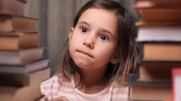 little girl looking at stacks of books and choosing which book to choose to read. little girl in the library choosing a book for herself. Choosing a book to read video