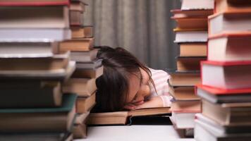 little girl got tired of learning to read and fell asleep on a book. concept of children getting tired of learning. child sleeps on a book surrounded by stacks, symbolizing school stress video
