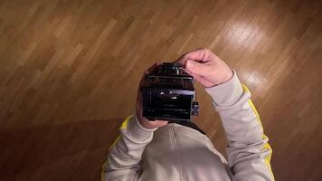 pov First person view Photographer using vintage twin lens reflex camera, capturing image from above on wooden floor, showcasing classic photography technique video