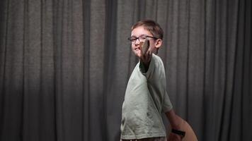 boy knight hits with a sword. The boy attacks with a wooden sword. A boy with glasses plays knight, warrior with a sword. video