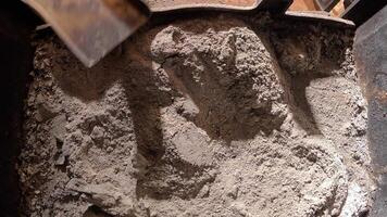 top view. view from inside fireplace. Housekeeper cleans a fireplace filled with ashes using a metal shovel. The process involves removing waste and maintaining a cozy, warm indoor environmen video