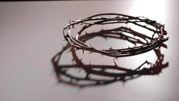 Crown of thorns creates dynamic shadows on a smooth surface as soft lighting shifts, producing an intense visual effect that evokes themes of sacrifice and spirituality video