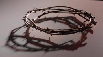 Crown of thorns casting a distinct shadow on a white background symbolizes pain, suffering, and sacrifice within the context of christianity and religious faith video