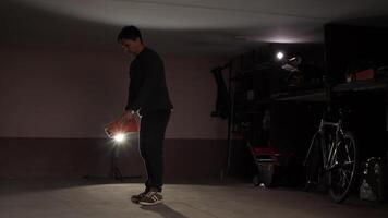 A man is standing in a dark room with a flashlight video
