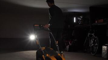 A man is using a lawn mower in a garage video