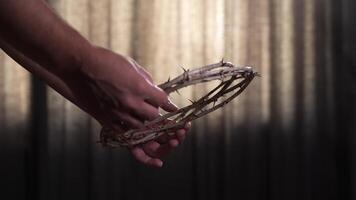 Hands hold a crown of thorns, symbolizing the suffering and sacrifice of jesus christ. This powerful emblem reflects themes of faith, redemption, and spiritual devotion within christianity video