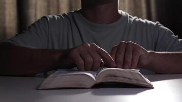 Man reads a holy book at a table, then clasps his hands in prayer. The scene captures a moment of reflection and devotion, emphasizing spirituality and faith video