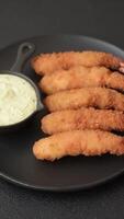 Hot crispy shrimp breaded with salt and spices with white sauce on a dark concrete background video