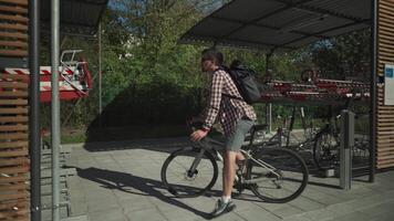 Man parks his bicycle in two-level bicycle parking lot in Munich, Germany. Double decker bicycle parking lot. Bicyclist parking his cycle in a split level bicycle parking lot. Cycling infrastructure video