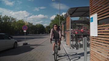 Man parks his bicycle in two-level bicycle parking lot in Munich, Germany. Double decker bicycle parking lot. Bicyclist parking his cycle in a split level bicycle parking lot. Cycling infrastructure video