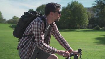 Cyclist uses smartphone on handlebars of bicycle to navigate. Male bicyclist rides his bike in park in Germany and use GPS to find way around. Man planning route application in mobile phone. video
