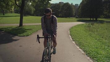 Cyclist uses smartphone application on handlebar of his bicycle to navigate while cycling in park in Germany. Man planning route using GPS navigation application in mobile phone while riding a cycle. video
