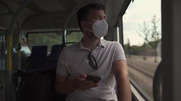 Commuting during pandemic. Public transportation curfew. Using cell phone while commuting to work on public transportation bus while wearing mask to prevent corona virus. Social distancing on bus video