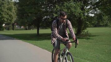 Cyclist uses smartphone application on handlebar of his bicycle to navigate while cycling in park in Germany. Man planning route using GPS navigation application in mobile phone while riding a cycle. video
