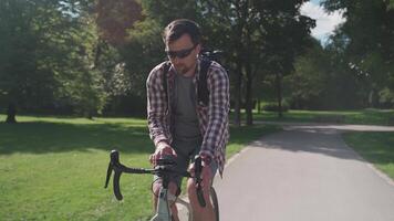 Man navigates course with GPS application on mobile phone on bicycle during ride in Germany park. Cyclist with backpack cycling on city bike and using smartphone on the handlebars to create a route. video