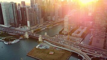 Chicago bridge and skyline at sunset with lens flare. Aerial view of Chicago's bridge and downtown buildings at sunset, with warm lens flare highlighting the urban architecture and river. video