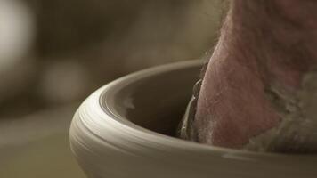 Potter working on a new piece vase in mud video