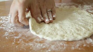 Making pizza dough. The cook's hands gently pull the edges of the dough to form a circle. video