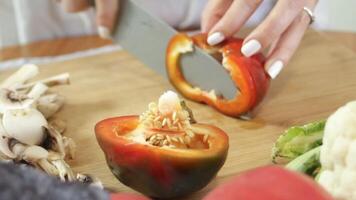 fatiamento vermelho fresco Pimenta. conceito do preparando legumes para fazer salada, pizza, massa e mais. video