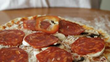 Pizza preparation. The cook puts slices of red bell pepper on the pizza base which is covered with tomato sauce, grated cheese, slices of mushrooms and spicy sausage. video