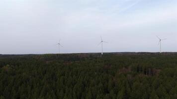 Aerial view of wind farm turbines set up in countryside with forest. Producing power using energy of nature. Incorporating technology into environment of nature. Cloudy sky. Electricity production. video