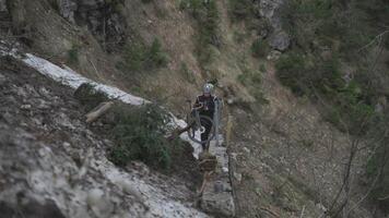 Man cyclist pulls bicycle through avalanche in mountains. Bicyclist is trapped in obstacle and is pulling his cycle through an ice slide with bicycle in his hands. Avalanche on cycling route in Alps. video