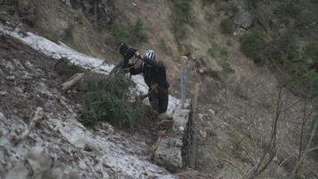 Man cyclist pulls bicycle through avalanche in mountains. Bicyclist is trapped in obstacle and is pulling his cycle through an ice slide with bicycle in his hands. Avalanche on cycling route in Alps. video