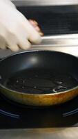 Bacon slices in frying pan. Man hands put bacon on frying pan. Unhealthy food. Vertical video