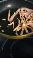 Cooking bacon for breakfast. Chef turns crispy bacon in frying pan. Ingredients for burger. Close up. Vertical video