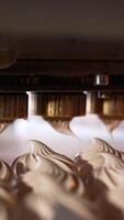 Automated line with rotating nozzles producing vanilla marshmallows. Close up. Food factory concept. Vertical video