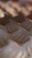 White creamy marshmallows identical in size and shape. Vanilla zephyr manufactured at food factory. Close up. Vertical video