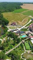 Recreational spa resort situated in the rural territory. Beautiful area for relax and fun at the backdrop of farmlands. Aerial view. Vertical video