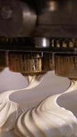 Machine producing white vanilla marshmallows. Creamy desserts are laid on the conveyor line. Close up. Vertical video